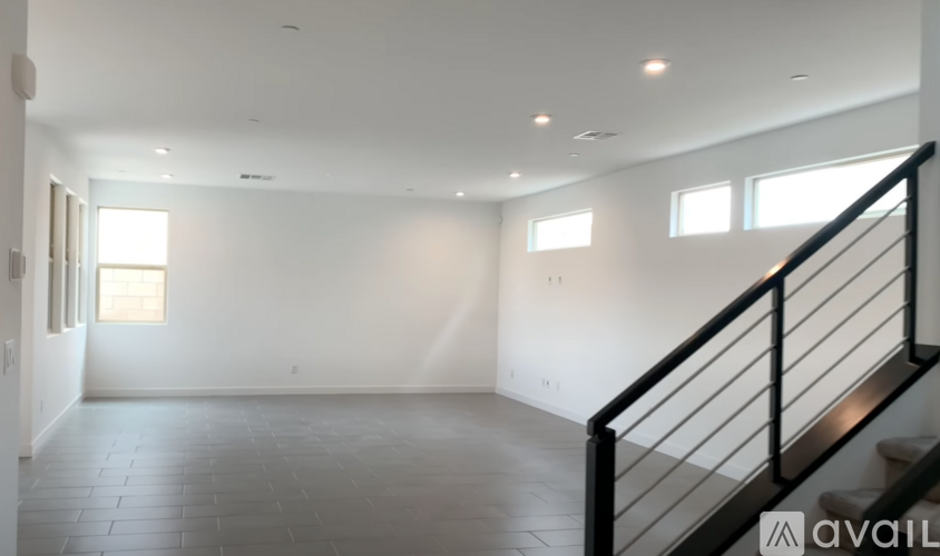 A spacious room with a staircase and windows.
