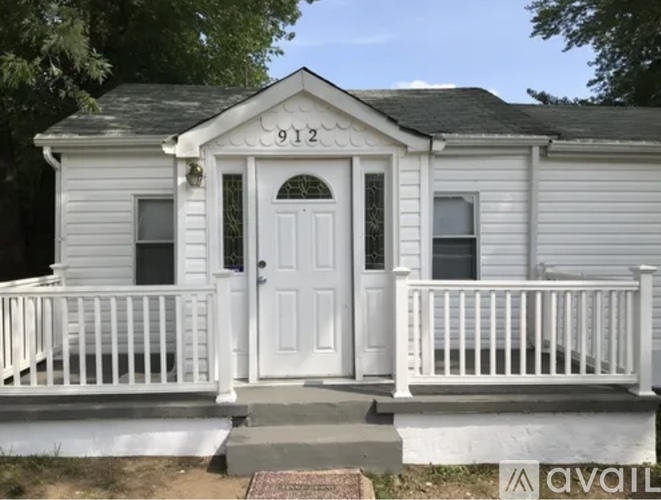 A small white house with the number 912 on the front door.