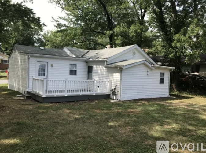 A white mobile home with a porch and a small deck.