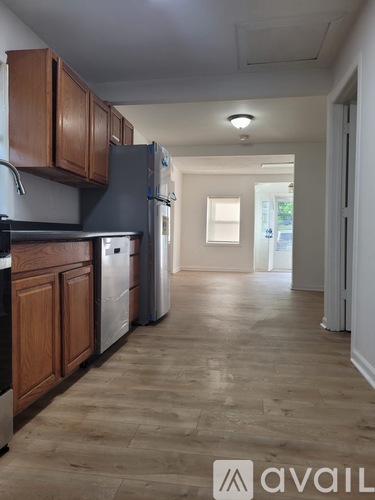 A kitchen with wooden cabinets and a refrigerator.
