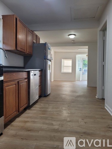 A kitchen with wooden cabinets and a refrigerator.