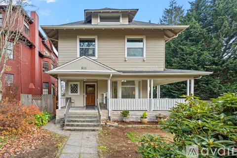 A two-story house with a front porch and a white picket fence.
