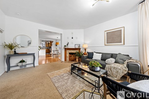 A living room with a grey couch and a glass coffee table.