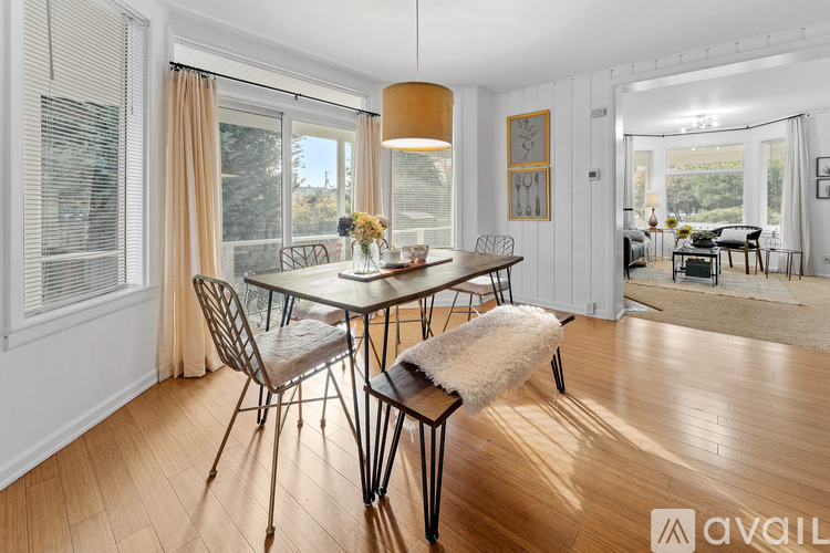 A dining room with a table set for four and a view of the backyard.
