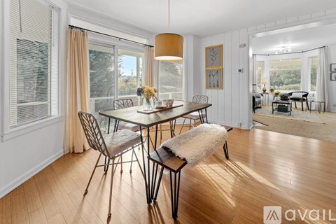 A dining room with a table set for four and a view of the backyard.