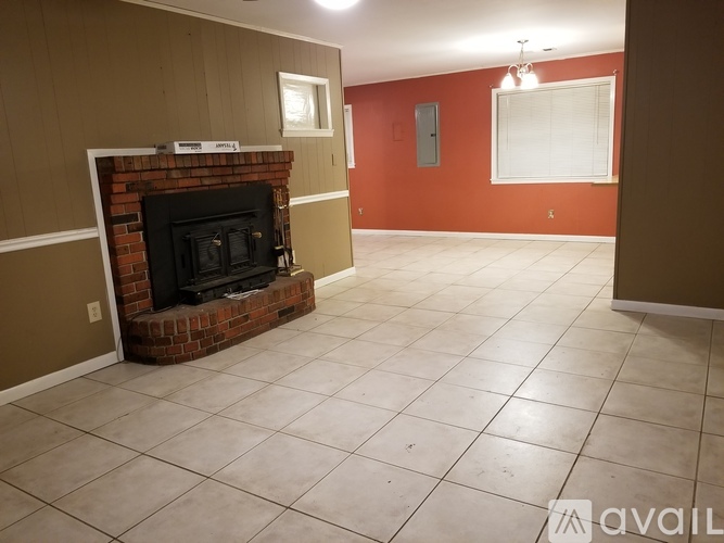 A room with a fireplace and tile flooring.