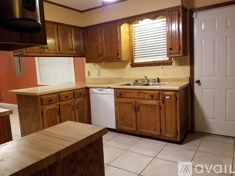A kitchen with wooden cabinets and a white dishwasher.