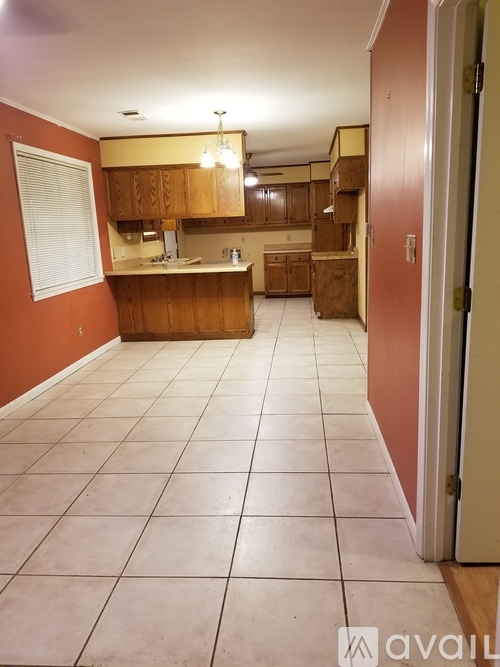 A kitchen with wooden cabinets and a tiled floor.