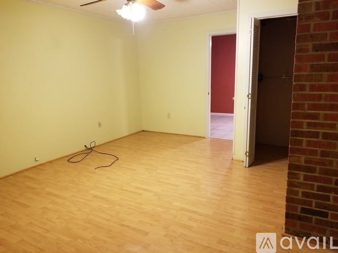 A room with wooden flooring and a red door.