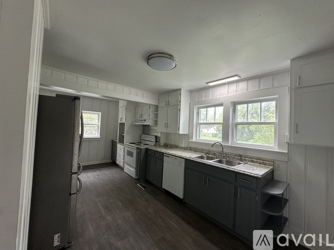 A kitchen under renovation with white cabinets and a grey island.