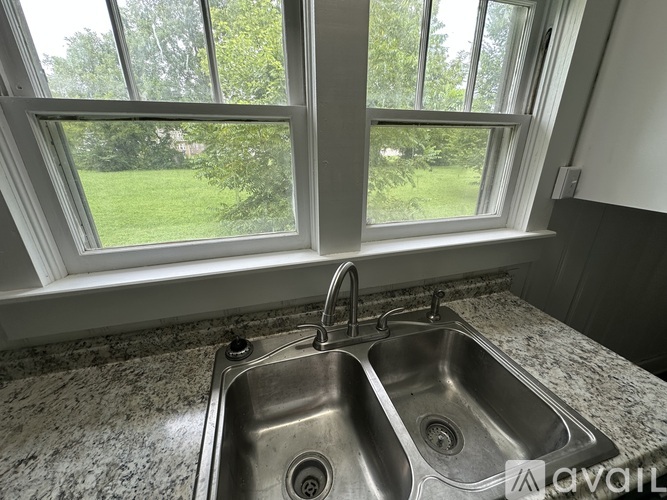 A bathroom with a toilet, sink, and mirror.