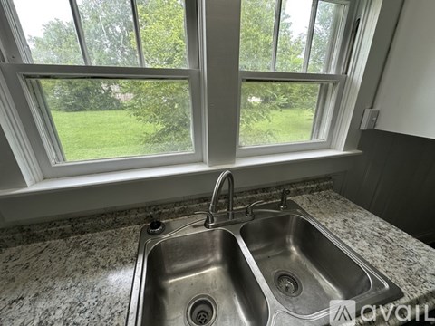 A bathroom with a toilet, sink, and mirror.