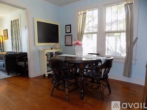 A dining room with a wooden table and chairs.