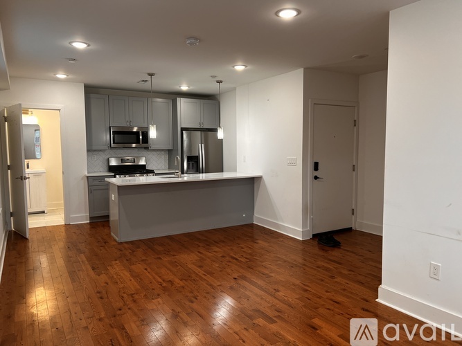 A kitchen with wooden floors and white walls.
