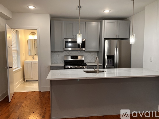 A modern kitchen with a large island and stainless steel appliances.