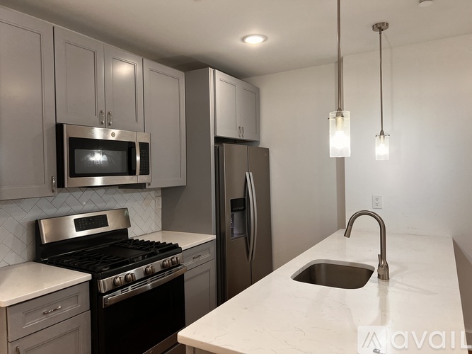 A kitchen with a stove, microwave, and refrigerator.