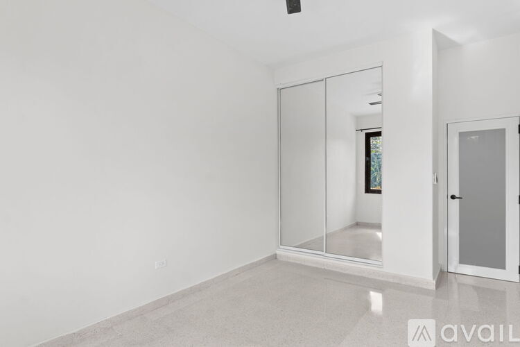 A spacious room with a white floor and a glass door.