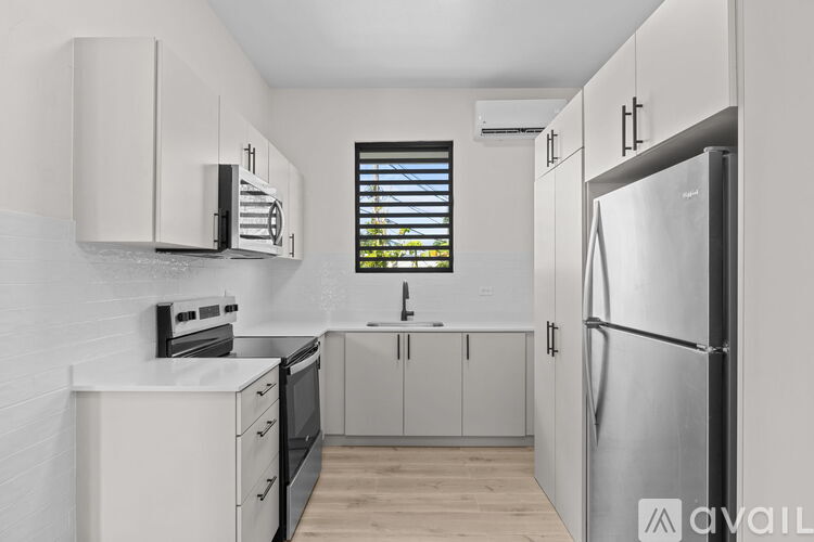 A kitchen with white cabinets and a stainless steel refrigerator.