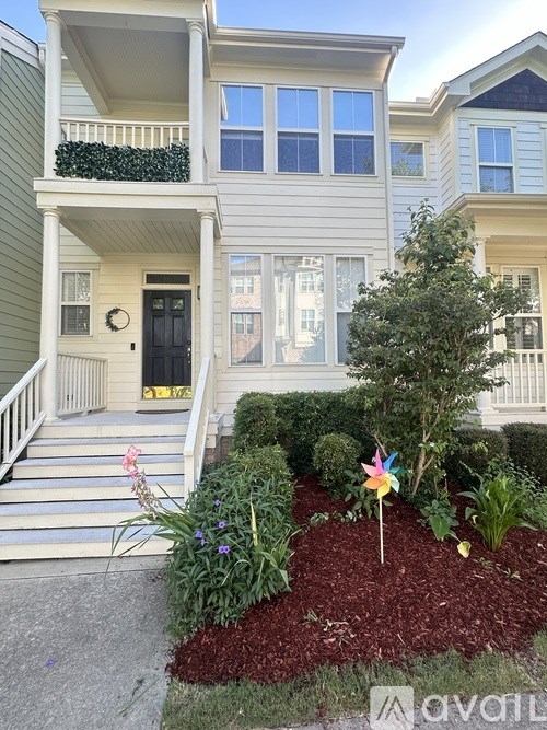 A house with a front yard and a small tree.