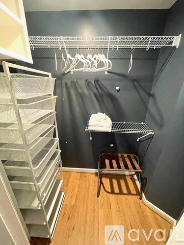A laundry room with a clothes drying rack and a folded towel.