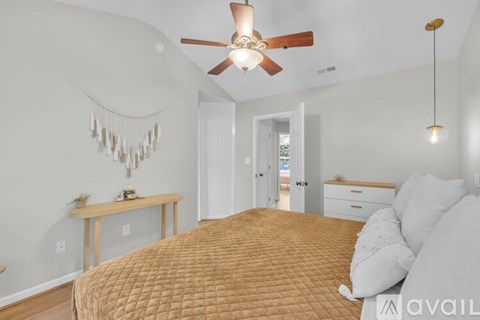 A bedroom with a bed, a ceiling fan, and a window.