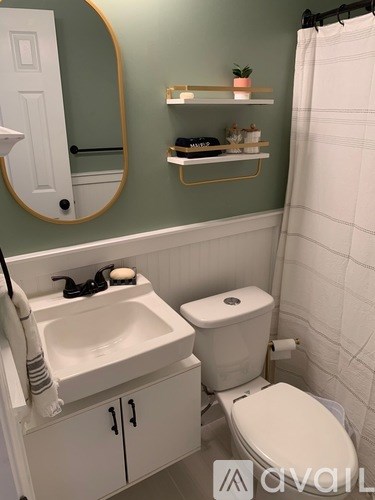 A bathroom with a toilet, sink, and a mirror.