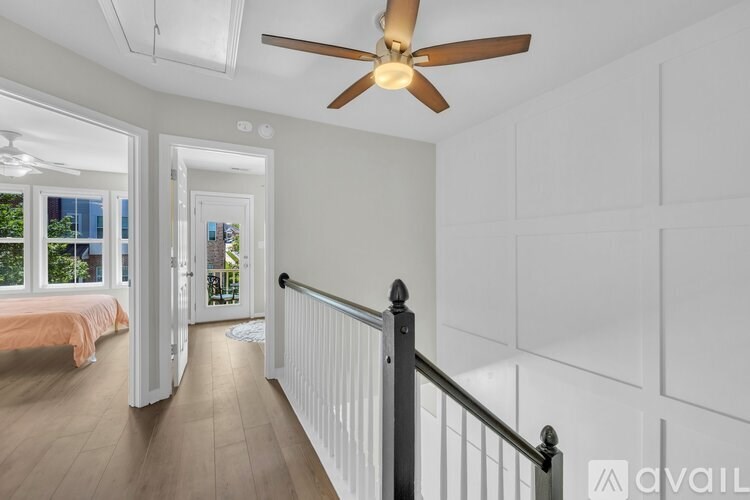 A room with a ceiling fan and a staircase.