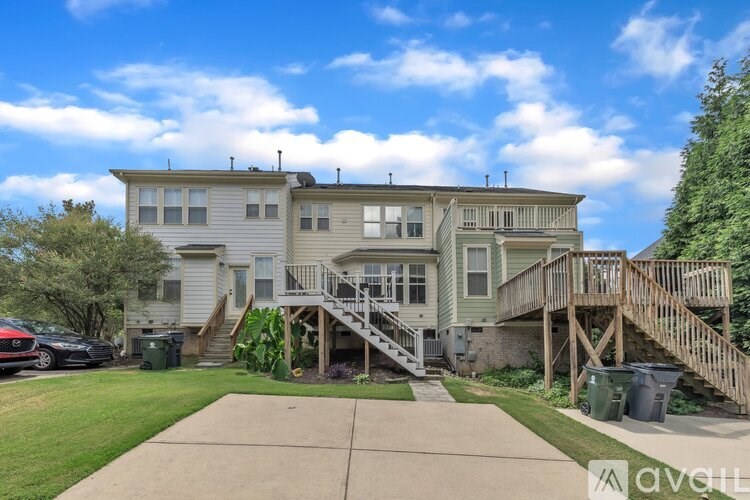 A two-story house with a deck and a driveway.