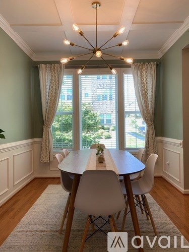 A dining room with a table and chairs.