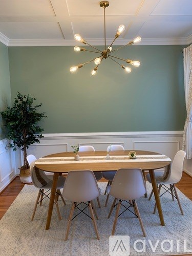 A dining room with a round table and chairs.