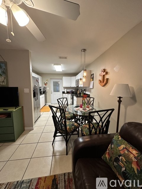 A living room with a brown leather couch and a glass table with chairs.