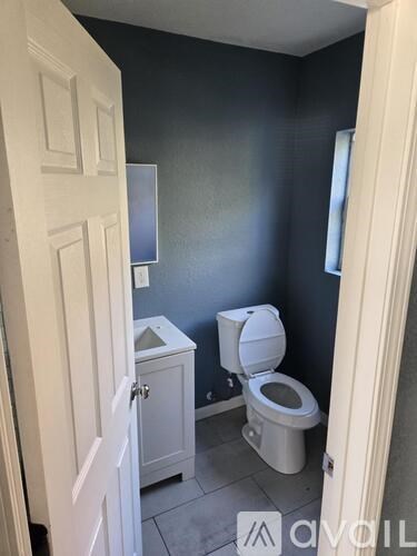 A white toilet sits in a bathroom with a white door.
