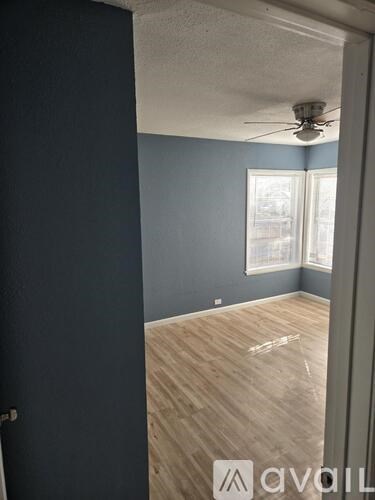 A room with a ceiling fan and a window.