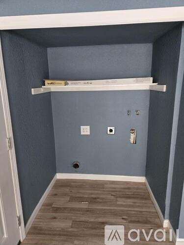 A small room with a white shelf and a door.