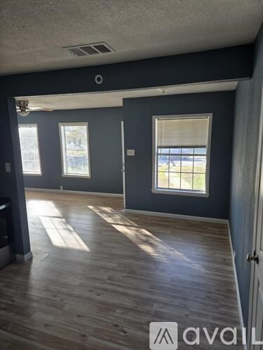 A room with wooden floors and a window overlooking a balcony.