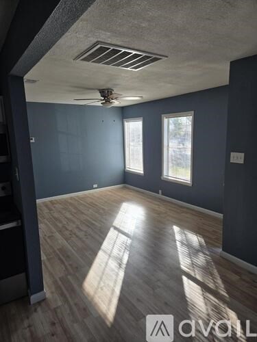 A room with wooden floors and a ceiling fan.