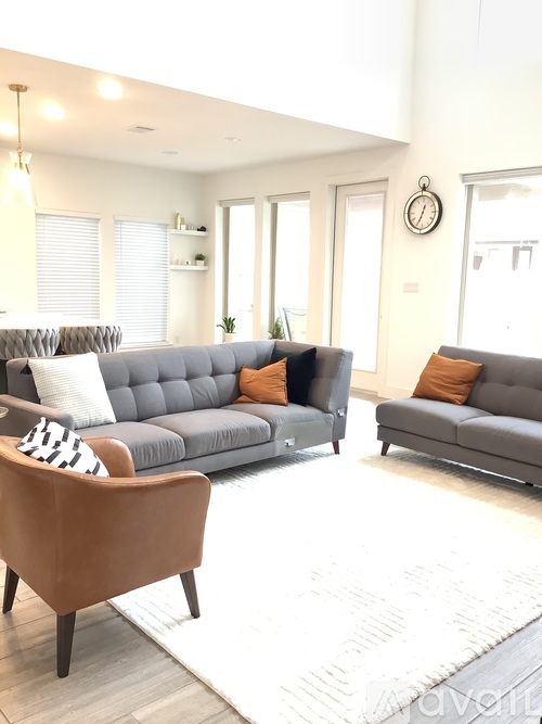 A living room with a grey sofa and a brown chair.