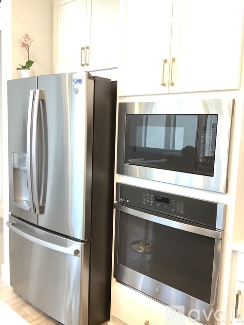 A stainless steel refrigerator and microwave oven in a kitchen.