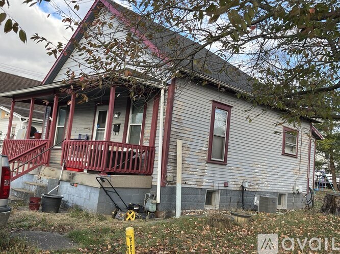 A house with a red railing and a grey siding.