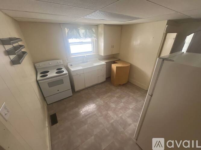 A small kitchen with a white stove and a window.