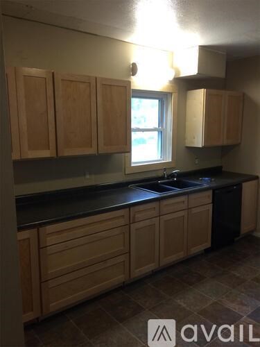 A kitchen with wooden cabinets and a black countertop.