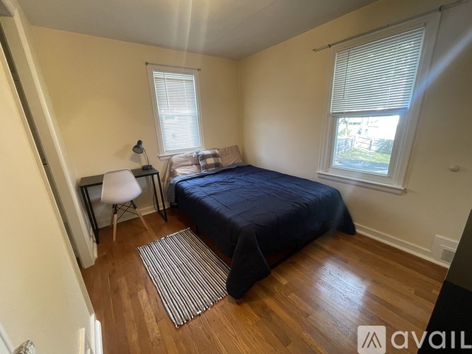 A bedroom with a bed, chair, and window.