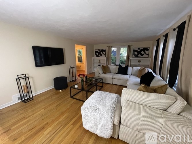 A living room with a white couch and a black coffee table.