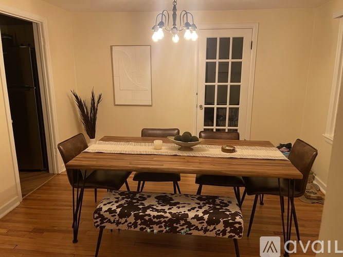 A dining room with a wooden table and chairs.