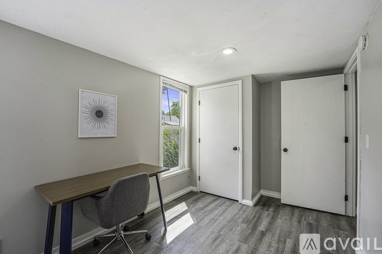A room with a desk and a chair in front of a window.