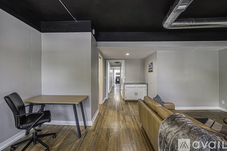 A room with a wooden floor and a black chair.