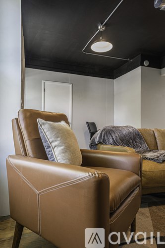 A brown leather chair with a cushion and a pillow is in the foreground.