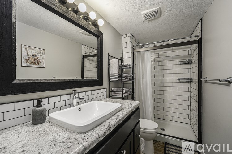 A bathroom with a sink, mirror, and toilet.