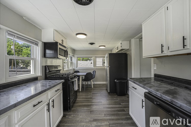 A kitchen with black appliances and white cabinets.