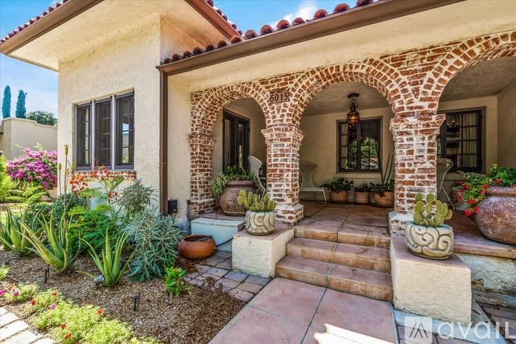 A house with a red tile roof and a stone archway entrance.
